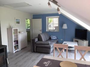 a living room with a couch and a tv at Möwe in Lancken-Granitz