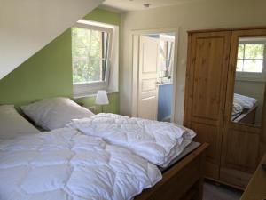 a bedroom with a large white bed and a window at Möwe in Lancken-Granitz