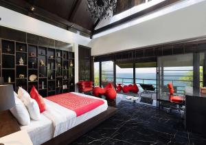 a bedroom with a large bed with red pillows at Villa Yin-Noi, Private Oceanfront Villa, Kamala Beach in Kamala Beach