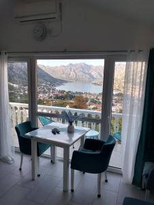 Beautiful view في كوتور: طاولة وكراسي في غرفة ذات نافذة كبيرة