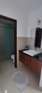 ein Badezimmer mit Waschbecken, Toilette und Spiegel in der Unterkunft Serenidad Palmas in Santa Cruz de la Sierra