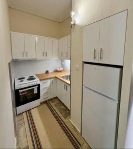 a kitchen with white cabinets and a white refrigerator at Dimitra's Little Beach House paradise by "elite" in Petalidhion