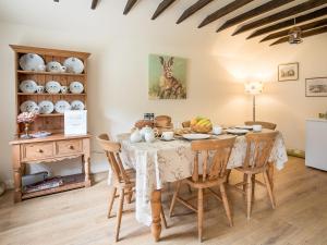 a dining room with a table and chairs and a room with a rabbit at Hudson Cottage - Uk38152 in Newton