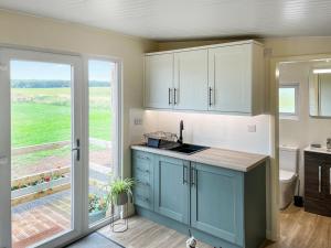 DishforthにあるRaygill Shepherds Hutのキッチン(青いキャビネット付)、大きな窓