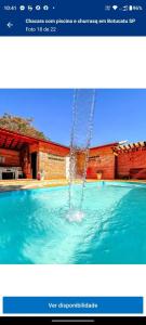 una fontana al centro di una piscina di Chacara Girassol a Botucatu