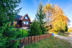 a wooden fence in front of a house at Bieszczadzki Domek z widokiem na połoniny in Wetlina
