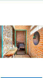 una camera con un muro di mattoni e un tavolo di Chacara Girassol a Botucatu