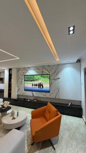a lobby with a couch and a tv on a wall at Luxury 3-Bedroom Duplexes with a Private Cinema Room and Game Lounge in Ibadan