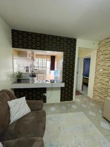 ein Wohnzimmer mit Couch und Küche in der Unterkunft Cozy Escape UTAWALA in Gatunga