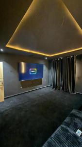 a room with a wall with a tv and curtains at Luxury 3-Bedroom Duplexes with a Private Cinema Room and Game Lounge in Ibadan +5 photos