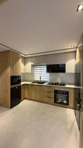 a large kitchen with wooden cabinets and appliances at Luxury 3-Bedroom Duplexes with a Private Cinema Room and Game Lounge in Ibadan