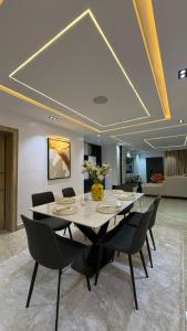 a dining room with a large table and chairs at Luxury 3-Bedroom Duplexes with a Private Cinema Room and Game Lounge in Ibadan