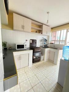 eine Küche mit weißen Schränken und einem Herd mit Backofen in der Unterkunft Cozy Escape UTAWALA in Gatunga + 9 Fotos