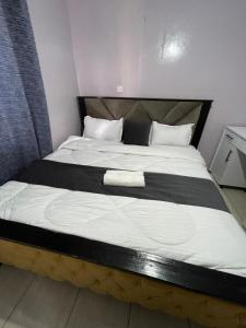 ein großes Bett mit einer schwarzen und weißen Decke in der Unterkunft Cozy Escape UTAWALA in Gatunga