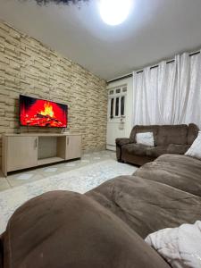 ein Wohnzimmer mit einem TV an einer Backsteinwand in der Unterkunft Cozy Escape UTAWALA in Gatunga
