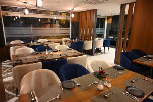 a restaurant with wooden tables and blue chairs at Good One Suites in Bengaluru