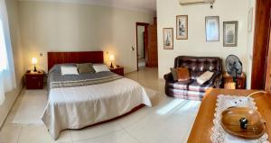 a bedroom with a bed and a couch at Seaview Family Apartment, Pool, Easy Access to the Sea, Near Mellieħa Bay in Mellieħa