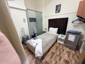 a small bedroom with a bed and a mirror at استوديو بجوار طلعت حرب in Cairo