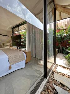 a bedroom with a bed and a large window at Pousada Okas de Camburizinho in São Sebastião