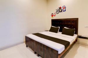 a bedroom with a large bed in a room at Hotel O KAILASHA INN in Hasanganj