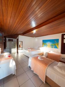 a bedroom with two beds and a wooden ceiling at Brisa do Caitá Praia Hotel in Morro de São Paulo