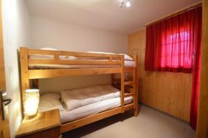 two bunk beds in a room with a red curtain at Platane B 04 in Grimentz