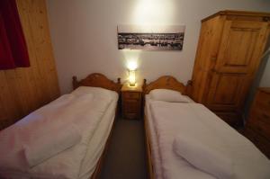 two beds in a small room with a lamp at Platane B 04 in Grimentz