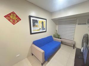 een woonkamer met een blauwe bank in een kamer bij 2Bedroom 2Bathroom AvidaRialaTowers with Pool Netflix in Cebu City