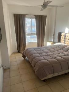 een slaapkamer met een groot bed en een raam bij Metro in Villa Gesell +28 foto's