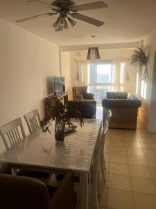 een woonkamer met een tafel met stoelen en een plafondventilator bij Metro in Villa Gesell