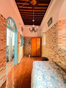 Un dormitorio con una cama y una pared de ladrillo. en L'Oa, en Rabat