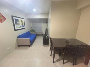 een woonkamer met een blauwe bank en een tafel bij 2Bedroom 2Bathroom AvidaRialaTowers with Pool Netflix in Cebu City