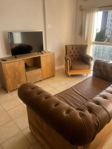 een woonkamer met een bank en een flatscreen-tv bij Metro in Villa Gesell