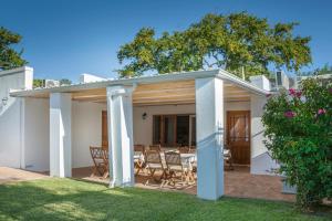 a patio with a table and chairs in a yard at Avenues Guest House in Stellenbosch