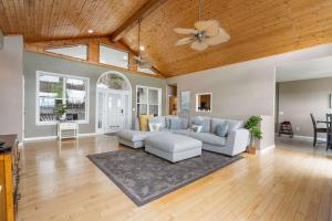a living room with a couch and a ceiling fan at The Greenview Manor with Lake Views in Kimberling City