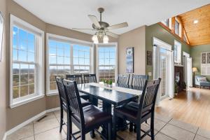 a dining room with a table and chairs and windows at The Greenview Manor with Lake Views in Kimberling City