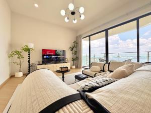 ein Wohnzimmer mit Blick auf das Meer in der Unterkunft Kingsbay Danga Bay Country Garden by Luxecocoo CK in Johor Bahru
