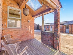 a patio with two chairs on a wooden deck at Garden Cottage - Uk45498 in Great Budworth