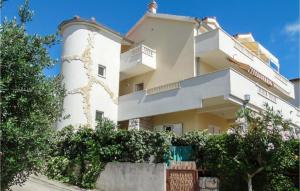 a large white building with trees in front of it at Nice Apartment In Omis With Wifi in Tice