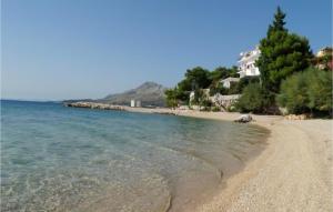 a beach with the ocean and houses in the background at Nice Apartment In Omis With Wifi in Tice +3 photos