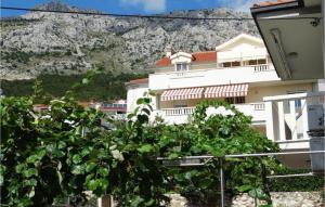 a white building with a mountain in the background at Lovely Apartment In Omis With Wifi in Tice
