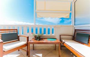 a balcony with two chairs and a table with a table at Lovely Apartment In Omis With Wifi in Tice