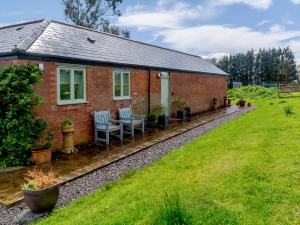a brick house with two chairs and a yard at Primrose in Shepton Mallet