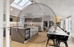 an open kitchen with a dining table and chairs at Beautiful Home In Idestrup With Sauna in Stovby