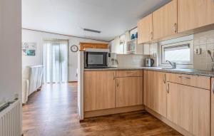 a kitchen with wooden cabinets and a microwave at 2 Bedroom Awesome Home In Erm in Erm +21 photos