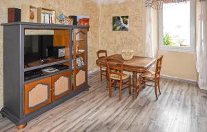 Lalevade-dʼArdècheにあるMaison En Pierresのテーブルとテレビのあるダイニングルーム