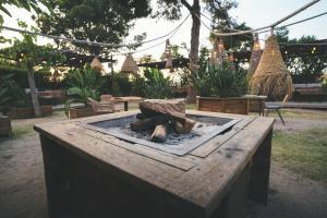 a wooden table with a fire pit in a yard at HolaCamp Sitges Garrofer in Sitges