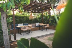a wooden deck with tables and chairs under a pergola at HolaCamp Sitges Garrofer in Sitges