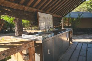 an outdoor kitchen with a sink and a stove at HolaCamp Sitges Garrofer in Sitges +11 photos