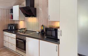 a kitchen with white cabinets and a black counter top at Stunning Home In Tarm With Sauna in Højsand